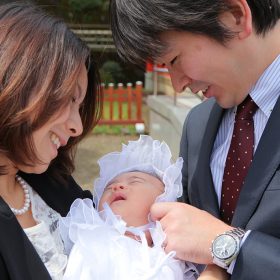 お宮参りの日に赤ちゃんを愛でるパパとママ