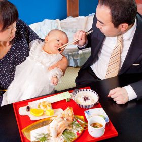 パパにお食い初めをしてもらう赤ちゃん